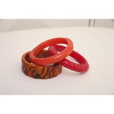 This is part of Chairish’s Costume Jewelry assortment.  The set of 3 art deco vintage authentic carved bangle bakelite bracelets are in the hues of red, amber orange and caramel. They are all hand carved and the orange caramel one is a thicker cuff with small swirls of black. The caramel on is 1.25" H x 3" W and the interior of that one is approx. 2.5" W. The other two are .5" H x 3.5" W and the other of those are 2.5" W. They will fit over a small medium wrist or medium wrist but not an extra w Vintage Amber Bangle Bracelet, Red Carved Vintage Jewelry, Carved Red Vintage Jewelry, Vintage Red Round Bangle, Vintage Handmade Red Bangle, Red Retro Bangle Jewelry, Vintage Red Adjustable Bangle, Vintage Carved Orange Jewelry, Handmade Bakelite Bangle Bracelet