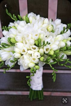 a bouquet of white flowers sitting on top of a chair