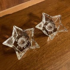 two glass dishes sitting on top of a wooden table