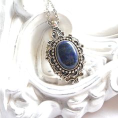 A lovely ornate pendant necklace in victorian style with a lapis  lazuli cabochon. Beautiful pendant hand made with silver tone components. Due to the natural origin of the cabochon, differences in color may occur. Cabochon size 13 x 18 mm. It is finished with a dainty chain. The chain measures approximately 50 cm. (21 inches) For more jewelry please visit our shop: http://minouc.etsy.com We also combine shipping with our other Etsy shop where we sell vintage fabrics and finds from Holland and F Blue Pendant Necklace, Vintage Style Necklace, Lapis Lazuli Pendant, Lapis Lazuli Necklace, Delft Blue, Dainty Chain, Blue Pendant, Blue Style, Necklace Vintage