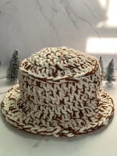 The S'mores Chunky Bucket Hat is a handmade crochet bucket hat made with two different color yarns in a one size fits all adults size. It is very soft and cozy, however it is not lined with fabric underneath so you may feel a bit of air though the brim. The neutral colors are perfect to pair with any winter outfits, offering a cozy and stylish look. White Cozy Chunky Knit Hat, Brown Yarn Brimmed Hat, Brown Hand Knitted Yarn Hats, Hand Knitted Brown Yarn Hat, Cozy Handmade Brown Hats, White Chunky Knit Casual Hat, Casual White Chunky Knit Hat, Beige Yarn Crochet Bucket Hat, White Yarn Bucket Hat With Short Brim