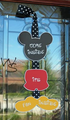 a mickey mouse sign hanging on the side of a glass door that says code inside