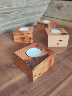 three wooden boxes with candles in them sitting on a table