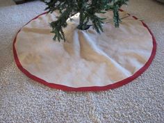 a christmas tree skirt is on the floor in front of a small fir - tree