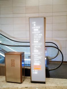 there is a large sign in the middle of an escalator and some boxes next to it