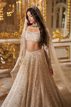 This lehenga set features all over thread embroidery in ivory and nude tones and highlighted with assorted pearls and crystals. It is paired with a full sleeves blouse. The sleeve hem shows exaggerated pearl tassels. The fully embroidered dupatta also shows pearl drops at all four sides.From Seema Gujral's Inara collection. DELIVERY TIMEPlease allow 8-12 weeks for your outfit to arrive. FABRIC DETAILSLehenga-Organza, Blouse- Organza, Dupatta - Organza Professional cleaning only. Elegant Lehenga With Dupatta For Ceremony, Organza Lehenga With Pallu For Wedding, Organza Lehenga With Sheer Dupatta For Reception, Gold Organza Lehenga For Wedding, Lehenga With Sheer Dupatta For Ceremonies, Ceremonial Lehenga With Sheer Dupatta, Ceremony Lehenga With Sheer Dupatta, Wedding Lehenga With Sheer Dupatta In Organza, Organza Lehenga With Sheer Dupatta For Wedding