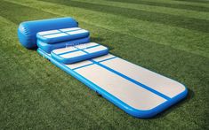 an inflatable pool on the grass with blue and white boards attached to it