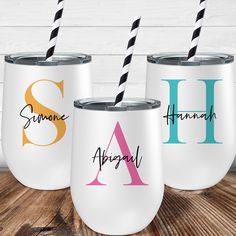 three personalized wine tumblers with monogrammed names and two drinking straws