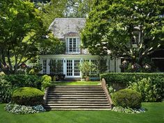 a house with steps leading up to the front door and trees in the back yard