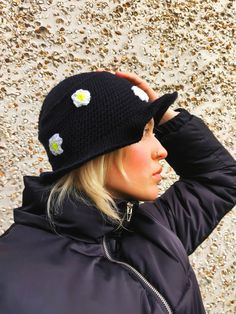 a woman wearing a black hat with flowers on it