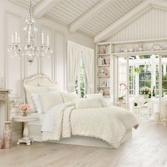 a bedroom with white furniture and chandelier