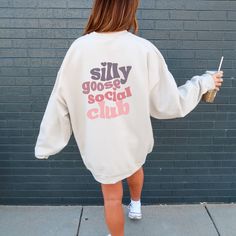 ✨ Step into comfort and style with my latest fall season sweatshirt design! This trendy oversized silly goose social club crewneck is all about silly vibes. A fun little expression to add a smile to your face. ✨The design is laid-back and casual, perfect for those lazy days or casual outings. This oversized unisex heavy blend pullover sweatshirt is cozy and comforting all in one. Made with a thick blend of cotton and polyester. It feels plush and soft, a perfect choice. ✨ Runs true to size ✨ Consider sizing up for oversized look ✨ Model sized up 2 sizes for this fit ✨ Loose fit ✨ 50% cotton, 50% polyester ✨ Medium-heavy fabric ✨ Tear-away label Casual Lettering Sweatshirt For Spring, Fall Slogan Sweatshirt For Leisure, Oversized Sweatshirt With Lettering For Loungewear, Oversized Lettering Sweatshirt For Fall, Fall Leisure Sweatshirt With Slogan, Trendy Fall Sweatshirt With Lettering, Oversized Fall Sweatshirt With Lettering, Peace Was Never An Option, College Crewneck