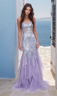 In soft lilac purple, this long sequin mermaid prom dress is a total feast for the eyes. With shimmering sequins from the sheer corset-style bodice to the hem, this long purple ruffled mermaid formal dress is a dazzling sight to behold whether you're attending prom, a pageant, or another black-tie event. The sheer-bodice long sequin evening gown has thin shoulder straps that lace-up over the cut-out back, while the hip-skimming long skirt has vertical ruffles that flow to the floor in glamorous Lavender Sequin Dress, Sparkly Purple Prom Dress, Sequin Mermaid Prom Dress, Pagent Dresses, Hoco 2024, Gowns For Prom, Fantasy Clothes, Gown For Prom, Sheer Corset