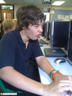 a young man sitting in front of a computer monitor