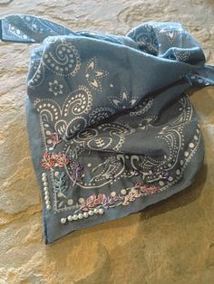 a blue bandana laying on top of a rock