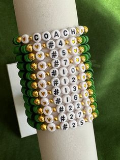 a close up of a napkin holder on a green surface with gold and white beads