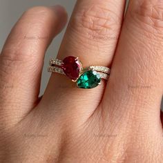 a woman's hand with a ring on it and two stones in the middle