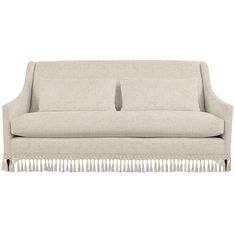 a beige couch with fringe trimmings on the arms and back, against a white background