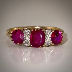 This is a beautiful antique English ruby and diamond ring from the late 19th century. Featuring three old cut rubies that graduate in size and are set in gold prongs. The central ruby's calculated weight is 0.64ct, based on estimated dimensions of 5.8 by 4.2 by 2.4mms (approx. TCW 1.1 ct). MEASURES: 7 ½ (US) - can be resized within reason by your skilled jeweler. Classic Three Stone Ruby Ring With Diamonds, Antique Ruby Ring With Single Cut Diamonds, Heirloom Three Stone Ruby And Diamond Ring, Heirloom Three-stone Ruby And Diamond Ring, Heirloom Three-stone Ruby Ring With Diamonds, Heirloom Three Stone Ruby Ring With Diamonds, Classic Red Three Stone Diamond Ring, Vintage Ruby Rings With Single Cut Diamonds, Heirloom Ruby Ring With Single Cut Diamonds