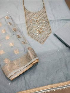 Item Overview ATHARVA Hand Embroidered Salwar Kameez w/Beautiful Embroidered Neck Grey/Banarsi Silk Dupatta/Latkan Tassel/Wedding/Bridal Trousseau Dno. CH1415 Fabric: * Shirt Chanderi Silk in Grey - 2.5 Mts, with Embroidered Neck * Dupatta: Banarsi Silk Dupatta - 2.5 Mts - (Motifs may wary) * Bottom Santoon Silk 2.5 Mts. Excusive Hand Embroidered Party Wear Punjabi Suit. Customization: * Fabrics Customization: Designs Can be made in different Fabrics. * Color Customization: Designs Can be made i Embroidered Sets For Wedding And Diwali, Embroidered Dola Silk Sets For Wedding, Wedding Sets In Dola Silk With Embroidery, Wedding Sets With Embroidery In Dola Silk, Semi-stitched Raw Silk Set With Gota Work, Eid Chanderi Unstitched Suit With Gota Work, Diwali Unstitched Jamawar Suit With Gota Work, Eid Gota Work Chanderi Unstitched Suit, Unstitched Jamawar Salwar Kameez With Gota Work