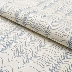 an upholstered fabric with wavy lines in white and blue on a plain background