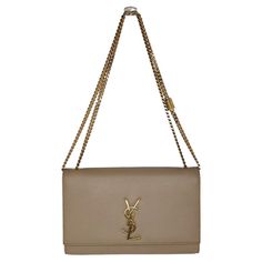 An iconic insignia nods to the Parisian fashion house's heritage on this chic shoulder bag designed in perfect proportions. Retail $2,400. Designer: YSL Saint Laurent Material: 100% Calfskin Origin: Italy Color(s): Dark Beige Measurements: 9 ½"W x 6"H x 2"D Strap Drop: 10 ¼" double; 19 ½" single Interior Lining: Grosgrain Opening/Closure: Flap top with YSL logo medallion snap Interior Pockets: One slip Hardware: Gold-tone metal Includes: Complimentary dust bag, care booklet and Entrupy COA Overa Ysl Saint Laurent, Side Edges, Ysl Logo, Parisian Fashion, Hardware Gold, Dark Beige, Chain Shoulder Bag, Parisian Style, Gold Tone Metal