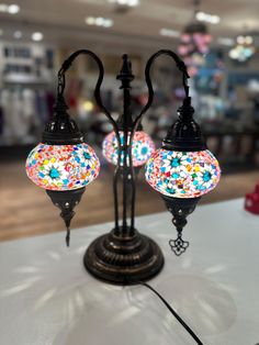 two colorful lights are on top of a white table in a shopping mall or store