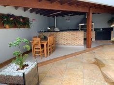 an outdoor kitchen and dining area with potted plants