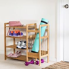 a wooden shoe rack filled with shoes next to a white door and rug on the floor