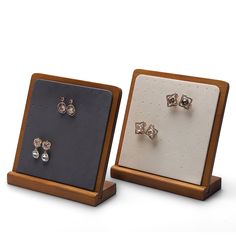 two pairs of diamond studs in wooden display cases