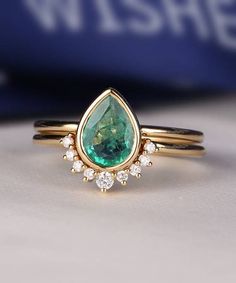 a close up of a ring with a green and white stone in the center on a table