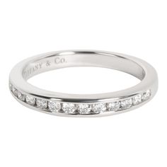 a white gold wedding ring with channeled diamonds on the side and an inscription that reads,