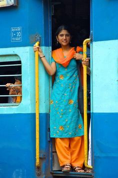 a woman standing in the doorway of a blue train