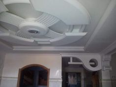 a room with a ceiling fan and white walls