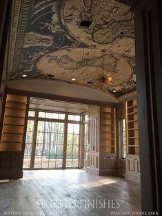 a large room with wood paneled walls and a ceiling painted with a world map