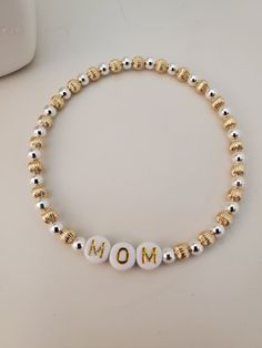 This is a beautiful sterling silver and 14kt gold fill beaded stretch MOM bracelet. We can also custom make with any name of your choice. This bracelet is made with the highest quality stretch magic cord. Chose your size. Silver Beaded Bracelets With Letter Beads For Mother's Day, Spiritual Silver Stretch Bracelet With Letter Beads, Mother's Day White Name Bracelet With 8mm Beads, Gold Bracelet With Letter Beads As Gift For Mom, Handmade Gold Stretch Bracelet For Mother's Day, Gold Beaded Bracelets For Mother's Day Gift, White Letter Beads Jewelry As Gift For Mom, Silver Spiritual Jewelry With Letter Beads, Spiritual Silver Jewelry With Letter Beads