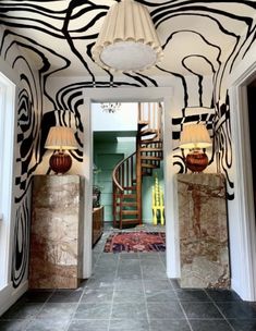 an entry way with zebra print on the wall and stairs leading up to another room