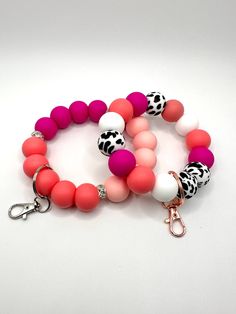 Finding your keys in your purse or bag can be frustrating, especially when you are trying to go somewhere.  Who has time to search for their keys.  With our Pink Cow designed keychain bracelet/wristlet, you can throw your worries away and attach your keys to this stunning design. Each keychain is made with high quality silicone beads.  Designed to slide on your wrist with ease (depending on your wrist size of course).  Attach your keys to the metal ringed lobster clasp.  Each bracelet is put tog Trendy Pink Wristlet With Keychain, White Round Beads Bracelets For Everyday Use, Everyday White Round Bead Bracelets, White Round Beads Keychains For Everyday Use, Handmade Trendy Wristlet For Everyday Use, White Beaded Keychains For Everyday Use, Trendy Handmade Wristlet For Everyday, Trendy Beaded Wristlet For Everyday Use, Multicolor Round Beads Bracelet For Everyday