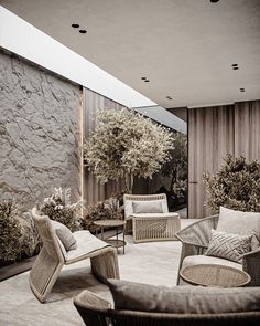 a living room filled with lots of furniture next to a wall covered in plants and trees