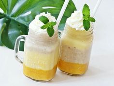 two mason jars with whipped cream and green leaves