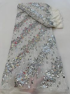 a white blanket with silver sequins on it