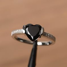 It is a natural black spinel ring. The main stone is 8mm*8mm heart cut, weight about 2.33 carats. The basic metal is sterling silver and plated with rhodium. To change the metal to a solid gold (white/rose) or platinum is also available, please ask for a quotation if you want. You can also go to my shop Home for more elegant rings: https://www.etsy.com/shop/godjewelry?ref=hdr_shop_menu More black spinel rings: https://www.etsy.com/shop/godjewelry/items?ref=seller-platform-mcnav&section_id=21 Black Heart Cut Jewelry For Wedding, Valentine's Day Black Diamond Jewelry, Black Heart-shaped Diamond Jewelry, Black Heart-shaped Jewelry For Anniversary, Black Heart Cut Heart Ring As Gift, Black Heart Cut Ring For Gift, Elegant Black Heart Ring For Weddings, Black Diamond Heart-shaped Jewelry, Black Diamond Jewelry For Valentine's Day