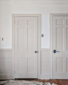 two white doors in a room with wood floors