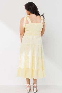 Our exquisite Plus Size Yellow Tiered Dress stunningly redefines the art of dressing with its intricately designed tiered style and contemporary square neckline. The Plus Size Yellow Tiered dress midi-length is skillfully prepared with a smocked bodice and tied shoulder straps that beautifully accentuate your silhouette, while granting superior comfort. This subtly elegant pastel yellow dress, is an ideal outfit for any occasion, promising to imbue you with a radiant confidence and fashionable sophistication all day long. Solid Should Tie Point Tiered Silhouette Light Fabric Midi Dress Length Square Neckline Smocked Bodice Sleeveless Light Pastel Yellow Length of 44" inches 95% Polyester 5% Spandex Be prepared to sway the onlookers with this must-have stylish addition to your wardrobe. Spring Tiered Sundress With Square Neck, Spring Square Neck Tiered Sundress, Spring Square Neck Sundress, Spring Tiered Midi Dress With Tie Straps, Spring Midi Dress With Tie Straps And Tiered Shape, Spring Midi Dress With Tie Straps And Tiered Design, Spring Smocked Midi Dress With Tie Straps, Summer Tiered Dress With Square Neck For Brunch, Chic Spring Tiered Dress With Square Neck