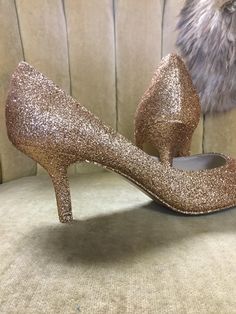 "These beautiful glitter high heels are covered in a rose gold glitter and sealed with a two step sealant that allows for movement and will not dull the shin of the glitter. This rose gold color is best described as a gold with a rose undertone. It is not an externally pink rose gold but does have a beautiful hint of pink undertones. Please note that the example heels in the photo are a size 8 shoe with a 3\" heel. Sizes 5-12 are available at checkout along with three different heel heights. All Gold Court Shoes With 4-inch Heel For Evening, Gold High Heel Court Shoes With 4-inch Heel, Gold Fitted Court Shoes With Low Heel, Gold Court Shoes With 4-inch Heel And Almond Toe, Gold Low Heel Heels With Deep Heel Cup, Glamorous Glitter Heels With Almond Toe, Gold Heels With Deep Heel Cup And Pointed Toe, Gold Pointed Toe Court Shoes With Deep Heel Cup, Gold Wedding Shoes With 4-inch Heel