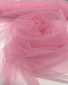 pink tulle fabric on white background, close - up image with focus on the rose