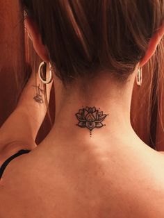 a woman with a tattoo on her neck and behind her ear is a lotus flower