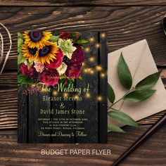 a wedding card with sunflowers, roses and greenery on top of a wooden table