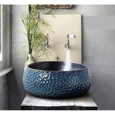 a bowl shaped sink sitting on top of a counter next to a wall mounted faucet