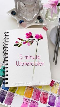 there is a notebook with watercolors on it